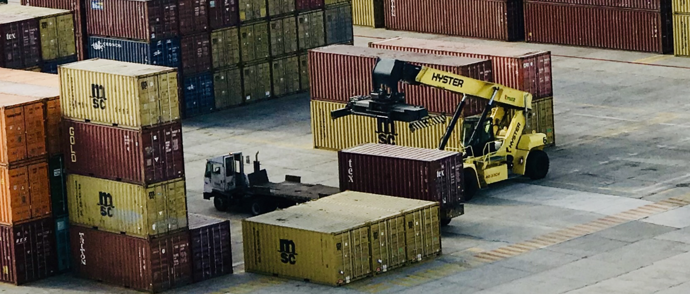 Picture of a forklift loading containers onto a truck